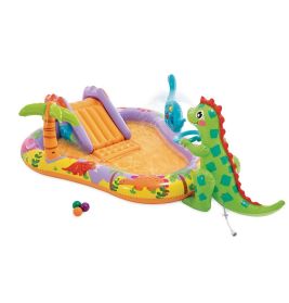 Aufblasbares Dino-Kinderplanschbecken mit Rutsche, Bällen, Palme und Wasserspritzern vor weißem Hintergrund.