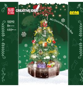 Schachtel eines Bausets mit geschmücktem Weihnachtsbaum, Geschenken und Lichtern vor schneebedecktem Hintergrund.