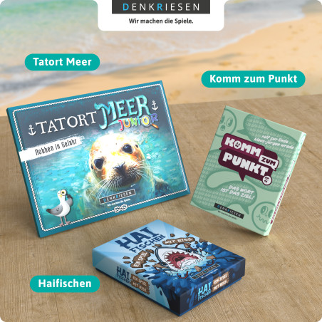 Drei DenkRiesen-Spiele-Tatort Meer, Komm zum Punkt, Haifischen-liegen auf einem Tisch am Strand.