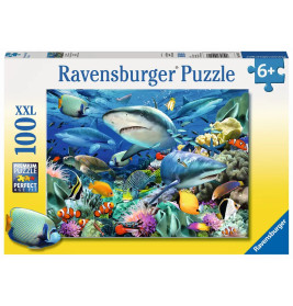 Ravensburger Puzzle mit 100 Teilen: Haie und bunte Fische schwimmen in einer lebendigen Unterwasserlandschaft.