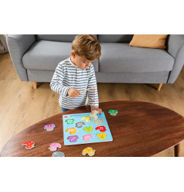 Junge spielt mit buntem Magnetpuzzle auf einem Holztisch im Wohnzimmer.
