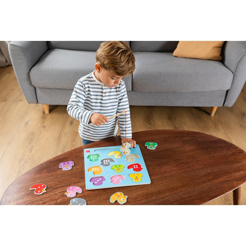 Junge spielt mit buntem Magnetpuzzle auf einem Holztisch im Wohnzimmer. Junge spielt mit buntem Magnetpuzzle auf einem Holztisch im Wohnzimmer.