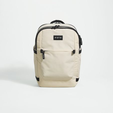 Beiger Rucksack mit schwarzen Reißverschlüssen und COTO-Label vorne, vor weißem Hintergrund fotografiert.