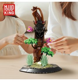 Zwei Personen bauen auf einem Tisch ein LEGO-Fantasiebaum-Modell mit rosa Blüten und grünen Blättern.