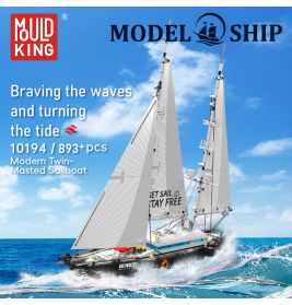 Ein Modellbausatz eines Zweimasters mit weißen Segeln fährt auf dem Meer unter blauem Himmel.