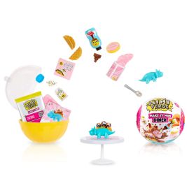 Mini-Food-Spielzeuge, Zubehör und ein blauer Dino auf weißer Tortenplatte mit gelber Kapsel und Verpackung.
