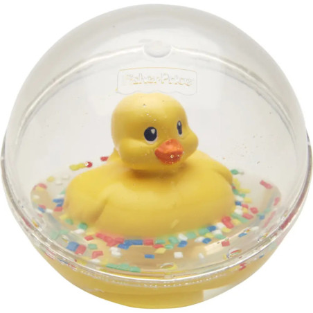 Gelbe Gummiente in einer transparenten Kugel, bunte Streusel am Boden.