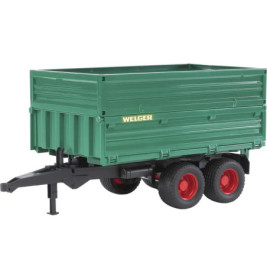 Grüner Welger-Anhänger mit roten Rädern und schwarzer Deichsel, von vorne links aufgenommen.