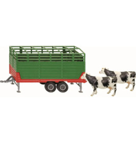 Grüner und roter Viehtransporter mit zwei schwarz-weißen Kühen daneben.