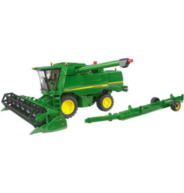 Grüner John Deere Mähdrescher mit gelbem Rad und angehängtem Schneidwerkswagen.