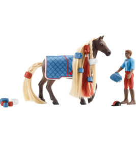 Spielzeugpferd mit geflochtener Mähne, blauer Decke und Zubehör neben einer Person in blau-roter Kleidung.