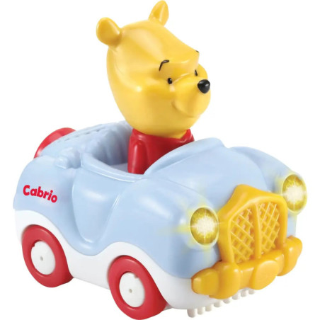 Winnie Puuh als Figur sitzt in einem blau-gelben Cabrio-Spielzeugauto mit leuchtenden Scheinwerfern.