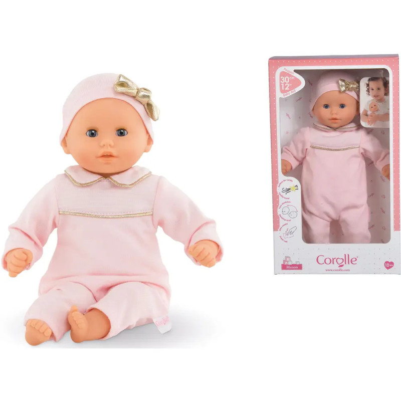 Babypuppe im rosa Outfit und Mütze mit goldener Schleife, sitzend und in Corolle-Verpackung abgebildet.