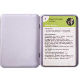 Offene Dose mit einer Karte darin, die eine Anleitung für ein naturwissenschaftliches Experiment auf Deutsch zeigt.