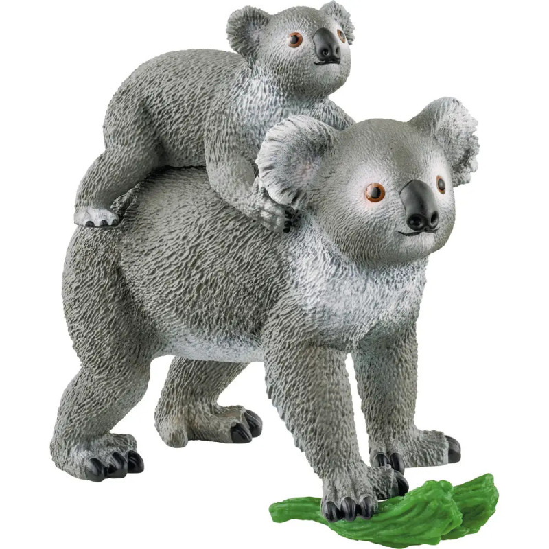 Spielzeug-Koala mit Baby auf dem Rücken steht bei grünen Blättern, beide aus strukturiertem Kunststoff gefertigt. Spielzeug-Koala mit Baby auf dem Rücken steht bei grünen Blättern, beide aus strukturiertem Kunststoff gefertigt.