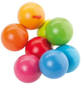 Acht bunte Holzkugeln, darunter Rot, Orange, Gelb, Grün, Blau und Pink, liegen eng beieinander.