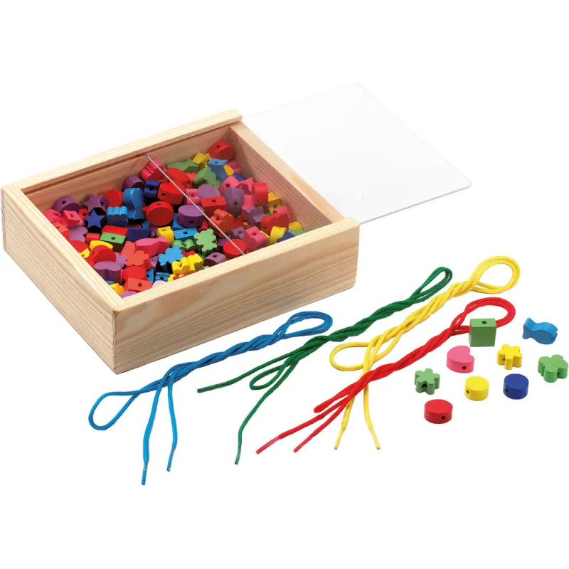 Holzbox mit bunten Fädelperlen und Schnüren, einige Perlen und Schnüre liegen daneben auf der Fläche.