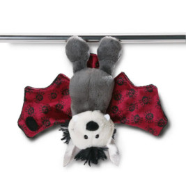 Plüsch-Fledermaus mit roten Flügeln und schwarzen Mustern hängt kopfüber an einer Metallstange.