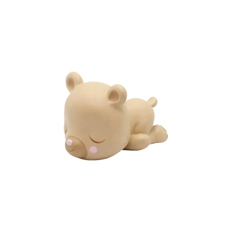 Beigefarbene Bärenfigur schläft auf dem Bauch, hat geschlossene Augen und rosafarbene Wangen. Beigefarbene Bärenfigur schläft auf dem Bauch, hat geschlossene Augen und rosafarbene Wangen.