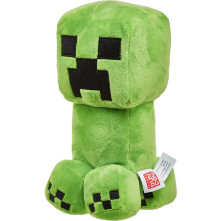 Grünes Plüschtier, das einem Minecraft Creeper ähnelt, mit quadratischen schwarzen Augen und Mund, sitzt aufrecht.