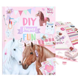 DIY-Bastelbuch mit Pferdezeichnungen, bunten Stickern und Bastelmaterialien auf rosa Hintergrund.