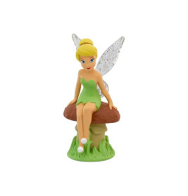 Fee mit blonden Haaren und glitzernden Flügeln sitzt im grünen Kleid auf einem Pilz und trägt weiße Schuhe.