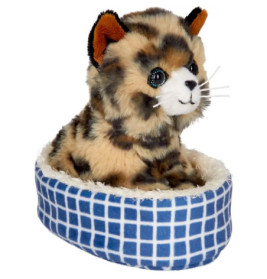 Eine Plüschkatze mit braun-schwarzem Fell sitzt in einem blau-weiß karierten Bett.