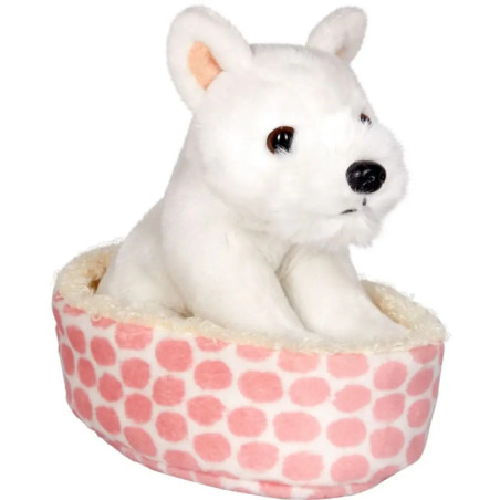 Weißes Plüschwelpen-Spielzeug sitzt in einem rosa-weiß gepunkteten Bett vor weißem Hintergrund. Weißes Plüschwelpen-Spielzeug sitzt in einem rosa-weiß gepunkteten Bett vor weißem Hintergrund.