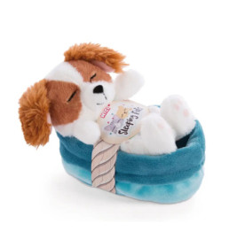 Plüschhund mit braunen Ohren schläft in blauem Bett und trägt ein Sleeping Pets-Label auf der Brust.