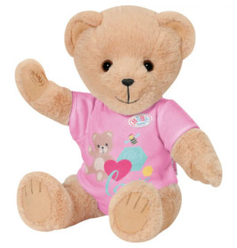 Ein hellbrauner Teddybär im rosa Shirt mit Bären- und Herzmotiv sitzt und winkt.