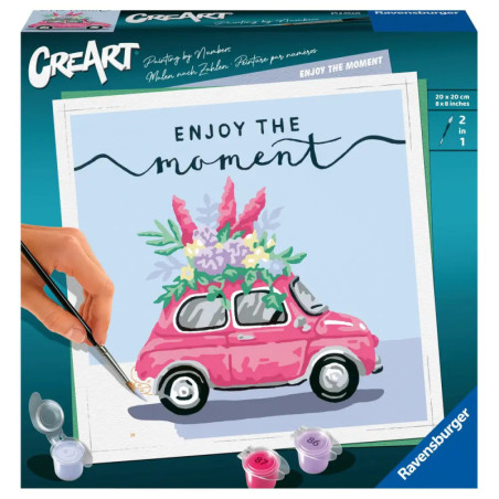 Eine Hand bemalt ein rosa Auto mit Blumen, dazu steht Enjoy the moment auf einer CreArt-Malkasten-Verpackung.