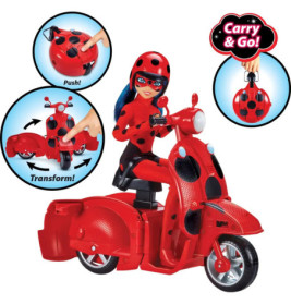 Marienkäfer-Puppe fährt einen roten Roller im Marienkäfer-Design, der sich in einen Tragekoffer verwandeln lässt.