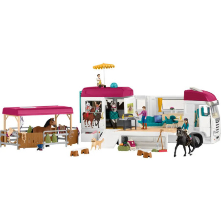 Spielset mit Pferdetransporter, Stall, Figuren, Pferden und Zubehör, arrangiert um den offenen Transporter.