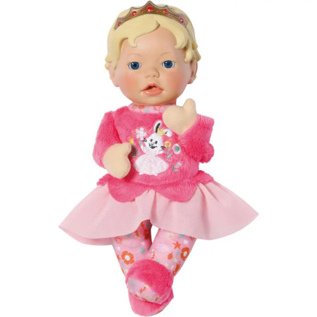 Blonde Babypuppe in rosa Kleid und Blumenleggings mit Krone sitzt aufrecht.
