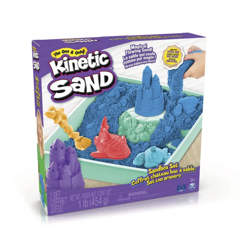 Box des Kinetic Sand Sandbox Sets mit blauem Sand, Förmchen und modellierten Sandskulpturen auf der Verpackung. Box des Kinetic Sand Sandbox Sets mit blauem Sand, Förmchen und modellierten Sandskulpturen auf der Verpackung.