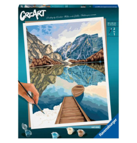 Eine Hand malt auf einer Malen-nach-Zahlen-Box einen Steg, ein Boot, einen See und Berge.