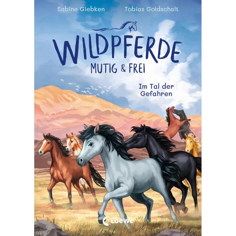 Sechs Wildpferde galoppieren über eine Wiese, im Hintergrund Berge unter blauem Himmel. Sechs Wildpferde galoppieren über eine Wiese, im Hintergrund Berge unter blauem Himmel.