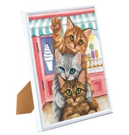 Drei verspielte Katzen übereinander vor einer Eisdiele, umrahmt von Weiß.