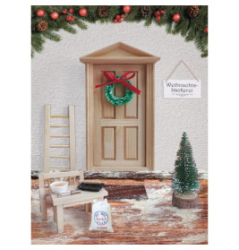 Miniaturszene: Weihnachtstür mit Kranz, Schild, Baum, Leiter, Stuhl und Backutensilien auf verschneitem Teppich.