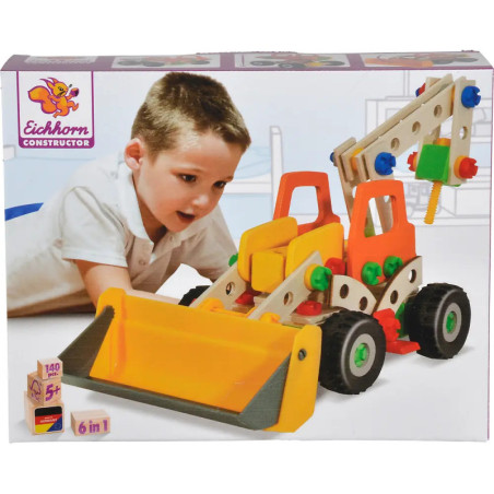 Ein Kind spielt mit einem bunten Baufahrzeug-Spielset auf einer Box mit der Aufschrift Eichhorn Constructor.