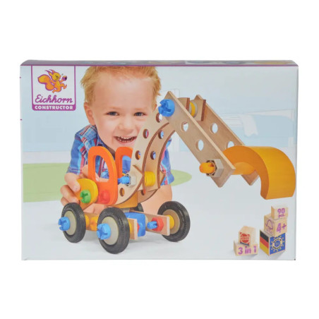 Lächelndes Kind spielt mit einem Holzbagger von Eichhorn Constructor, abgebildet auf der Produktverpackung.