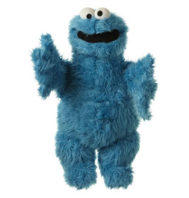 Ein blaues, zotteliges Puppenwesen mit großen Kulleraugen lächelt mit offenem Mund und erhobenen Armen.