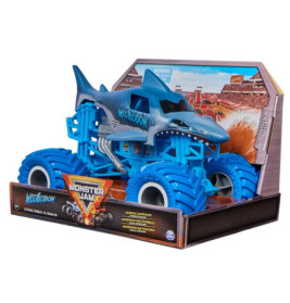 Blauer Megalodon-Monstertruck als Spielzeug im Hai-Design in Verpackung vor Stadion-Hintergrund.