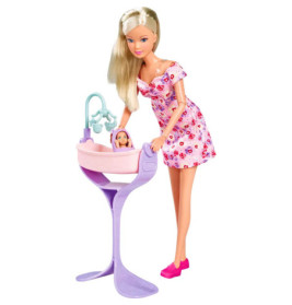 Puppe im rosa Blumenkleid steht neben einer Babypuppe in einem rosa-lila Spielbett.