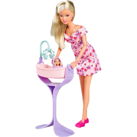 Puppe im rosa Blumenkleid steht neben einer Babypuppe in einem rosa-lila Spielbett. Puppe im rosa Blumenkleid steht neben einer Babypuppe in einem rosa-lila Spielbett.