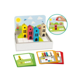 Bunte Spielzeughäuser und Karten liegen auf weißem Untergrund, eine Hand platziert ein Haus (siehe Einblendung).