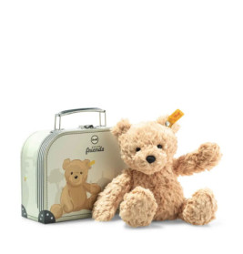 Ein Plüschbär sitzt neben einem kleinen Koffer, der mit einem Bärenmotiv verziert ist.