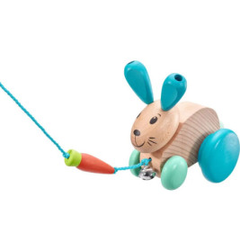 Holzhase zum Ziehen mit blauen Rädern und Ohren, befestigt an einer Schnur mit einer griffartigen Karottenende.