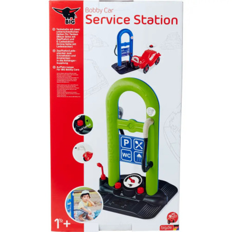 Spielzeug-Autowerkstatt im Karton mit grünem Bogen, blauem Schild und rotem Auto auf der Verpackung.