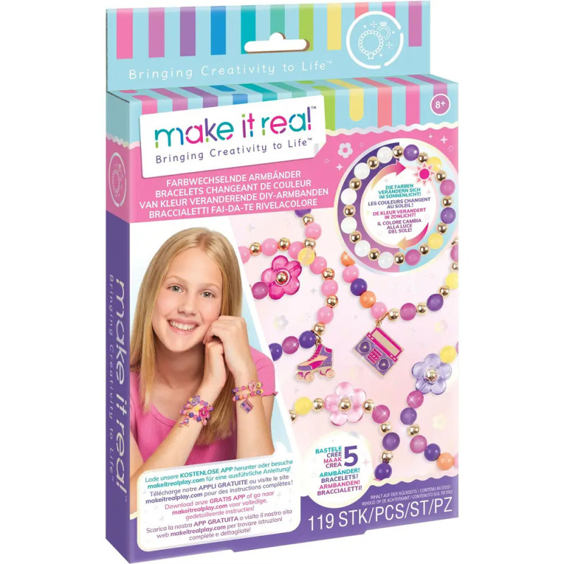 Mädchen lächelt mit bunten Perlenarmbändern Make It Real Schmuck-Bastelset Schachtel abgebildet.